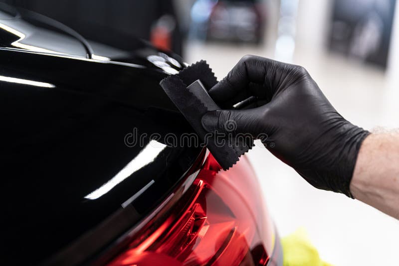 Professional ceramic coating application with black gloves